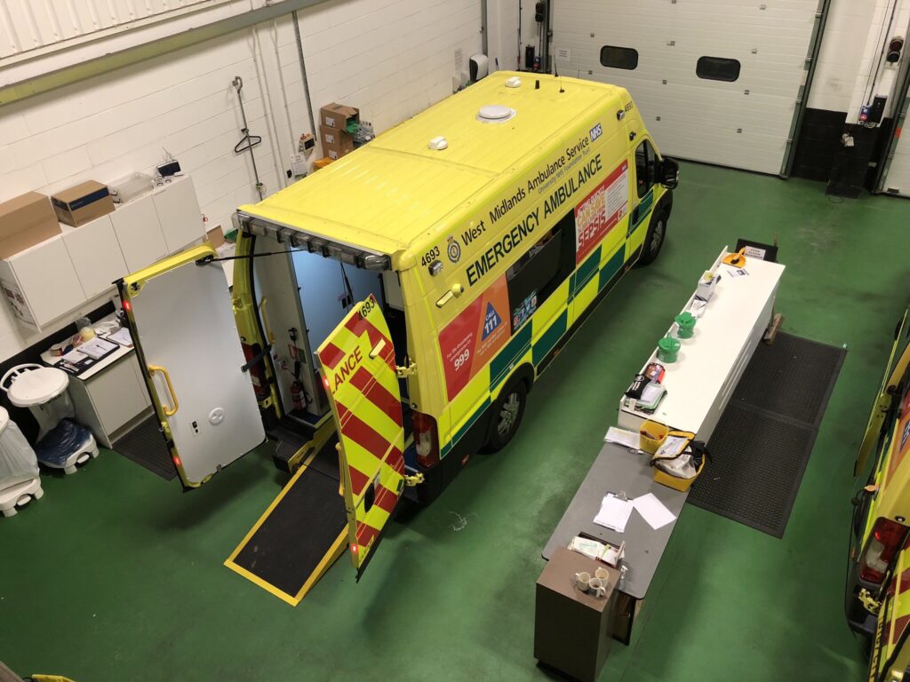 An Ambulance in the garage with the rear doors open