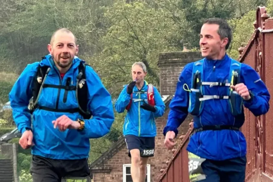 two men running over an iron bridge