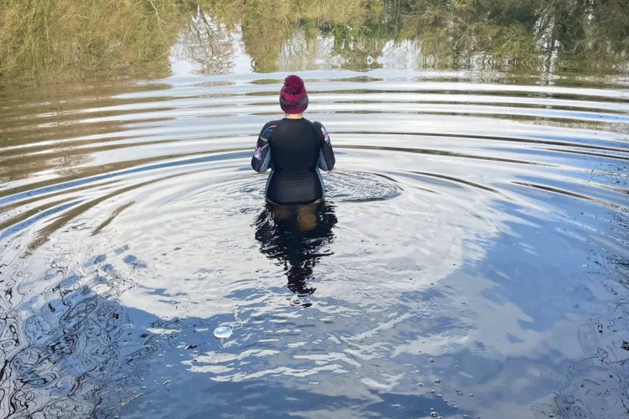 A lady in a wetsuit in a lake