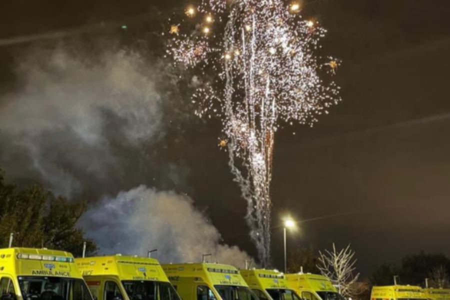 Fireworks in the sky over ambulances