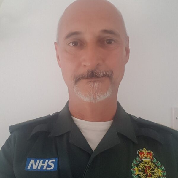 a man in a paramedics uniform in front of a white wall