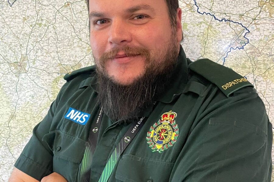 Photo of WMAS control room dispatcher Aaron Wilkes in uniform smiling at camera