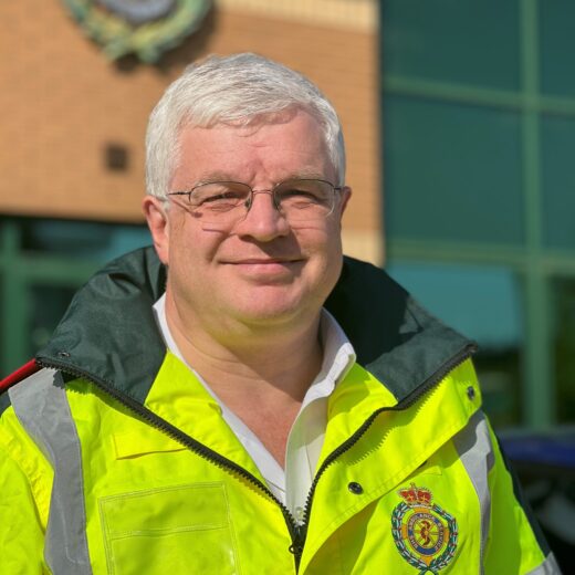 A man in a fluorescent jacket looking straight into the camera