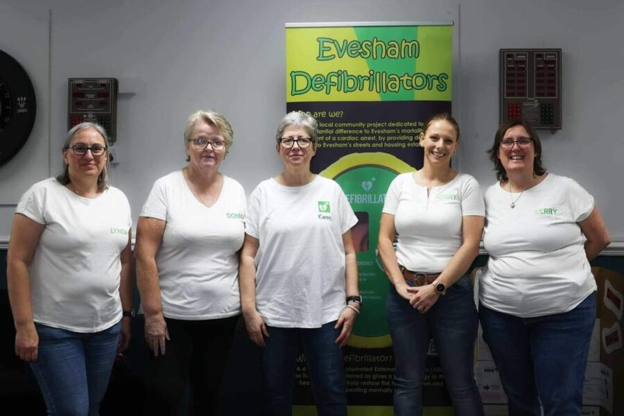 Five people standing in front of a sign